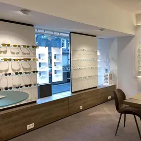 Modernes Optikergeschäft mit großer Auswahl an Brillen und Sonnenbrillen im Schaufenster.