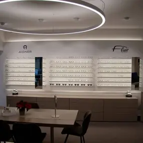 Modernes Optiker-Geschäft mit beleuchteter Brillenauslage und stilvollem Interieur.